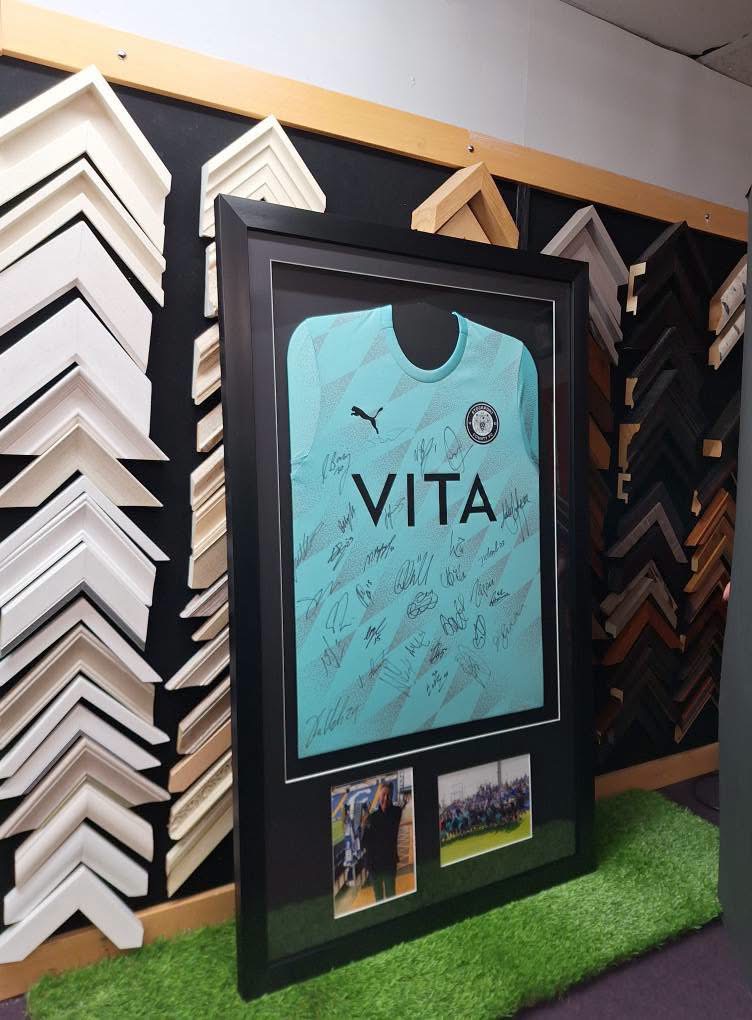 Hands positioning a jersey inside a deep frame