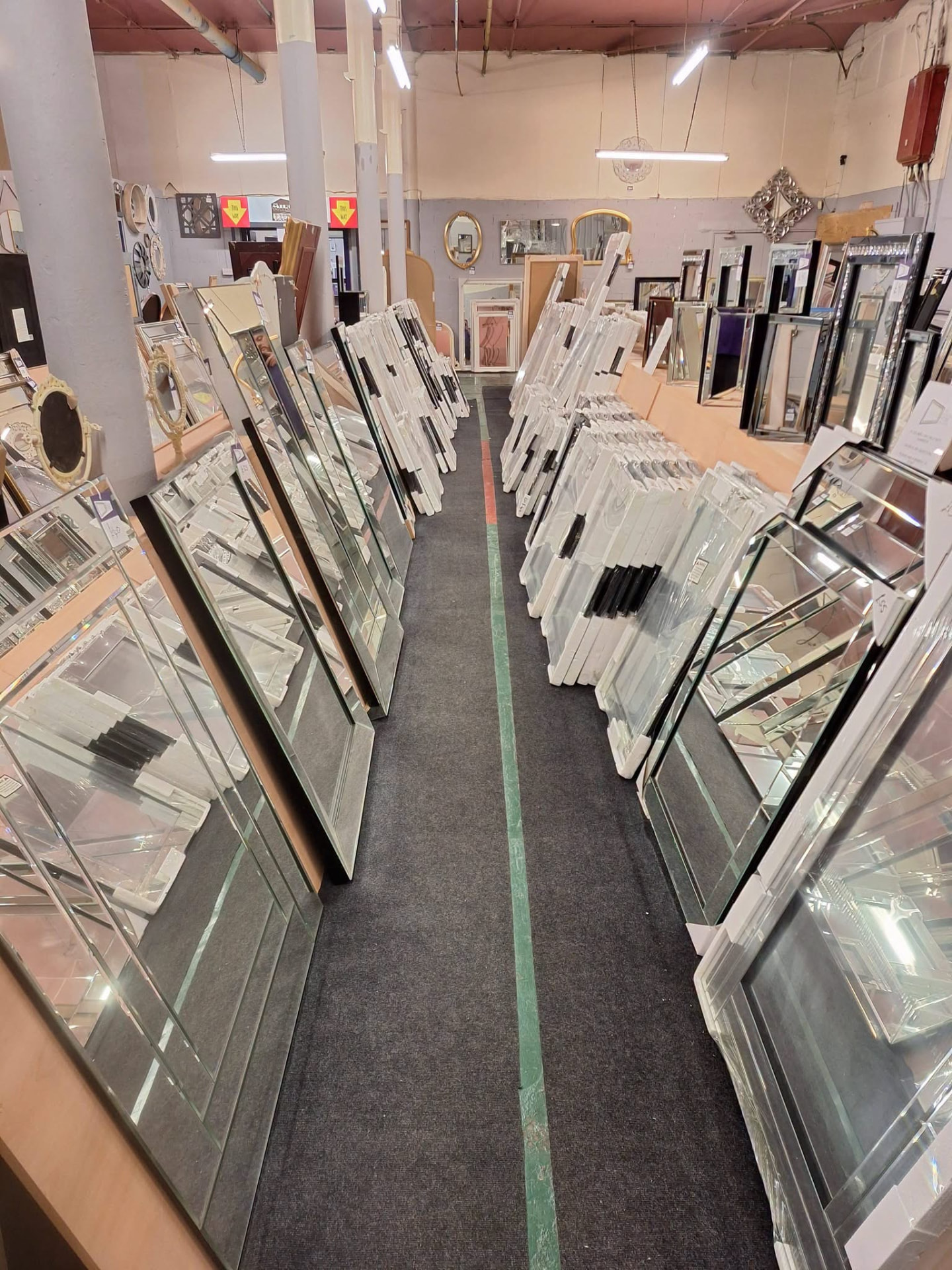 The showroom aisle lined with framed pieces, mirrors and sample frames